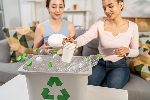 istock Two beautiful Asian women sorting plastic bottles for recycling at home. Attractive eco-conscious friends reusing materials and placing empty plastic bottles into recycling box. Net Zero Waste concept 2229016620