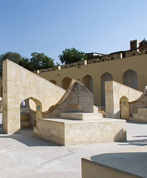 Ancient stone astronomical observatory instruments at jantar mantar in jaipur, india under a clear blue sky.