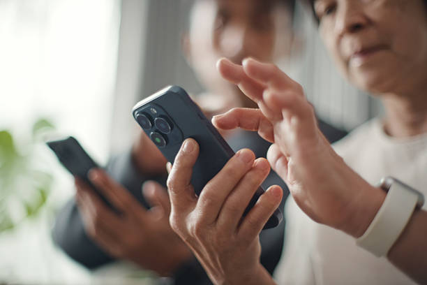 istock Mature and young sharing photos on smartphone. 2229020921