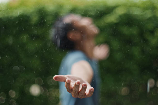 istock Man connecting with nature through the rain. 2229021057