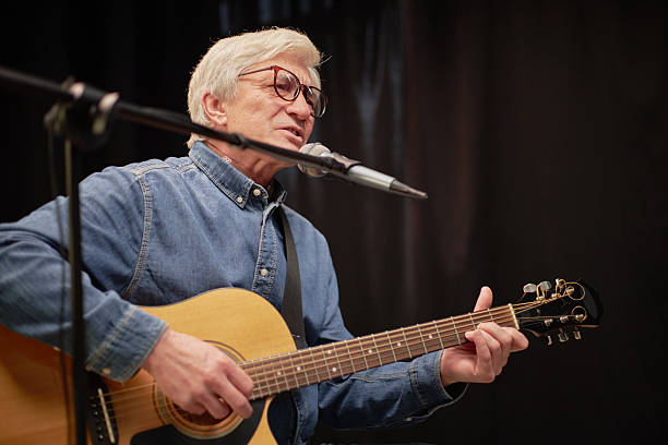 istock Senior Caucasian Man Singing and Playing Guitar during Talent Competition 2229024024