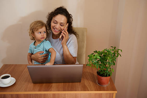 istock Mother Working Remotely While Caring for Child in a Cozy Home Office 2229024942