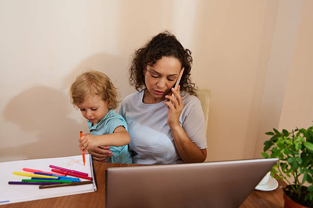 istock Mother Balancing Work at Home While Attending to Child's Activities 2229025148