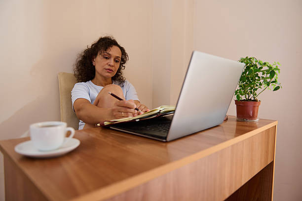 istock Woman Working Remotely in a Cozy Home Office Setting with Laptop 2229025486