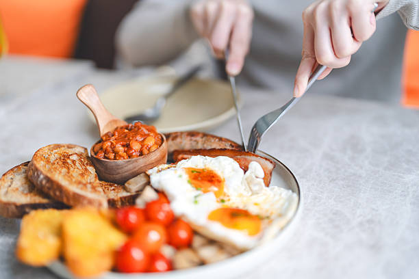 istock Eating english breakfast menu on marble table with tea fried eggs baked beans in tomato sauce and grilled bacon sausage tasty meal 2229029457