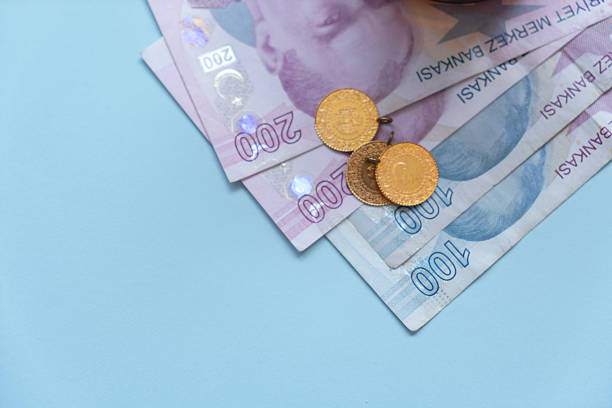Bankroll and gold, Turkish lira on blue background.Turkish Lira Turkish Gold Coins on Financial Chart Background