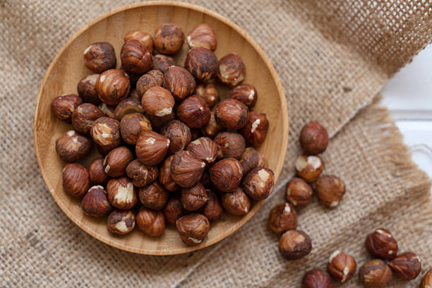 Bowl full of peeled hazelnuts on burlap sack