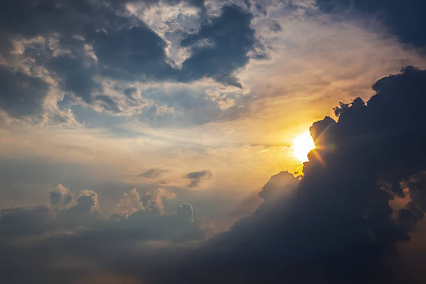 istock Dramatic cloudy sky with golden sunlight breaking through at sunset. A mix of dark storm clouds and soft illuminated areas creates a moody and atmospheric scene. 2229031416