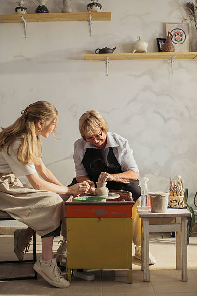 istock Senior woman learning pottery with teacher in workshop 2229033970