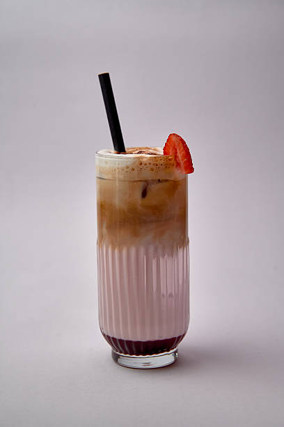 A Refreshing Dessert Drink Blending Creamy Layers of Strawberry and Coffee, Topped with a Slice of Fresh Strawberry for a Delightful Experience