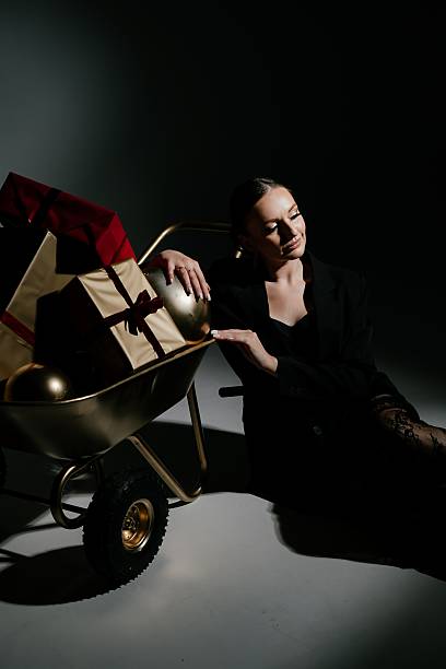 Pensive Woman by Gift Cart with Presents in Dark Setting