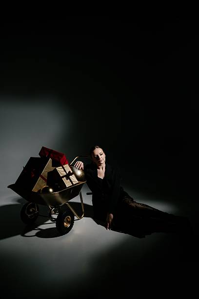 istock Woman Resting by Wheelbarrow Filled with Gift Boxes 2229041497