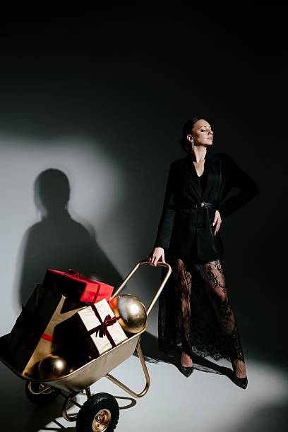 istock Elegant Woman with Gift-Laden Wheelbarrow in Studio 2229041684