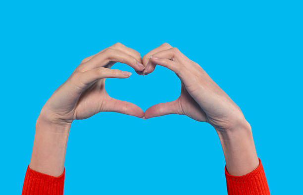 istock Hands forming a heart shape against a bright blue background in a creative and expressive display of affection and positivity 2229041770