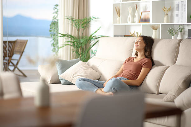 istock Happy woman relaxing on a sofa looking away at home 2229042036