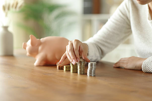 Woman hands counting savings on wooden table stock photo