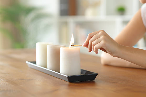 istock Woman hand lighting candles with a match at home 2229042371