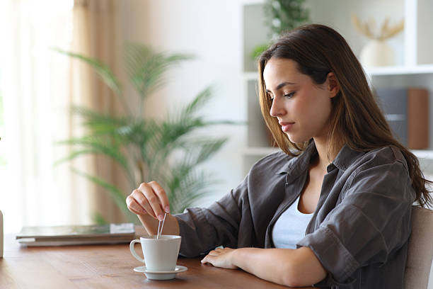 istock Distracted woman stirring coffee cup at home 2229042656
