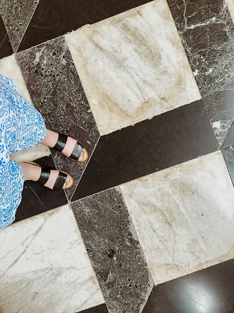 Worn geometric marble floor pattern with black and beige tiles in historical building interior, ancient architecture texture detail