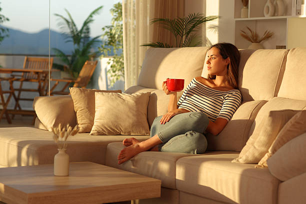 istock Woman relaxing drinking coffee from red cup at home at sunset 2229050271