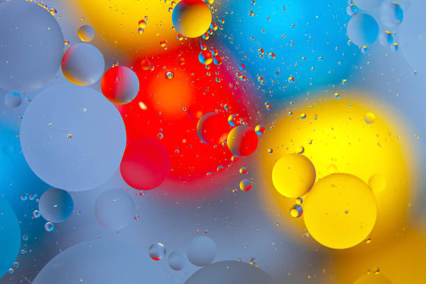 istock Abstract close-up of multicolored water drops on a glossy surface, blending red, yellow, blue, and green for a vibrant, artistic display. 2229052149