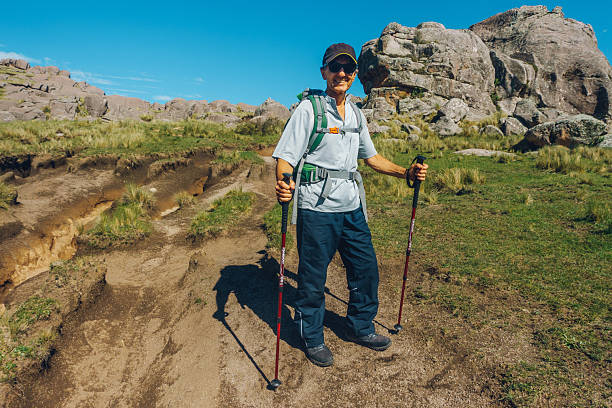Senior hiker trekking in the mountains enjoying a sunny day