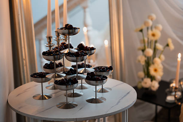 Beautiful wedding reception setup with tiered berries display, soft candlelight, and floral arrangements creating a romantic atmosphere