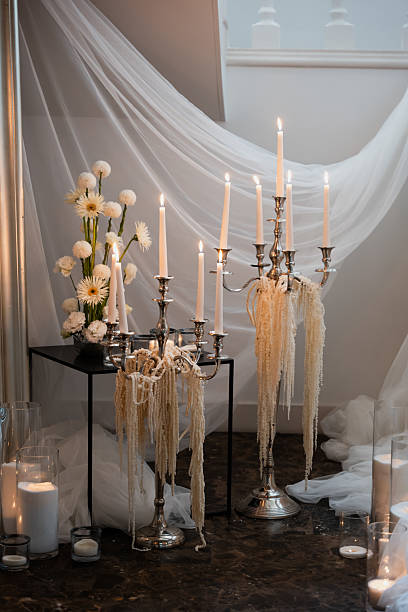Beautiful wedding reception setup with silver candelabras, white flowers, and soft drapery creating a romantic ambiance