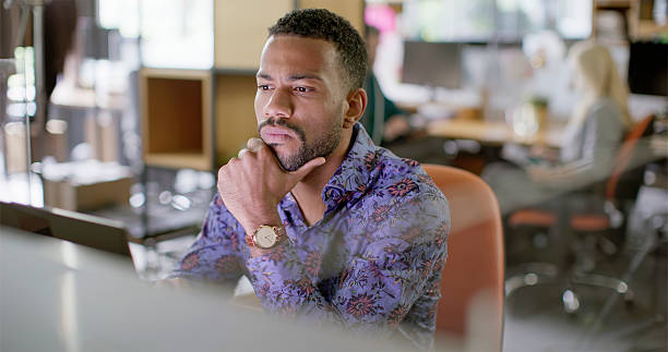 istock Focused Multiracial Businessman in Bright Office Working on Computer in Casual Blue Patterned Shirt 2229067368