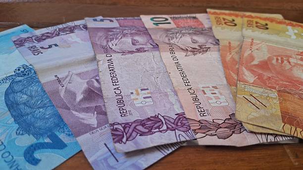 istock Brazilian real notes superimposed on a wooden background 2229067404