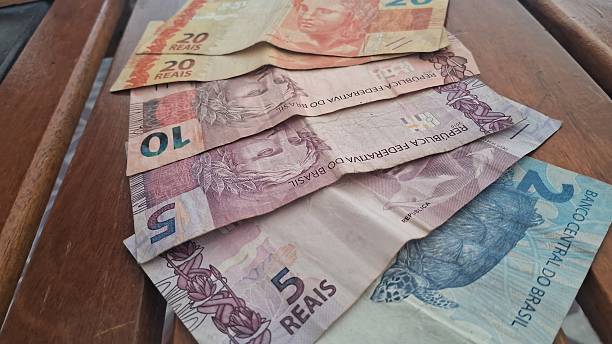 istock Brazilian real notes superimposed on a wooden background 2229067416