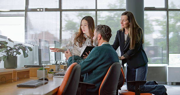 istock Diverse Business Team Collaborating in Modern Office with Bright Glass Windows 2229068924