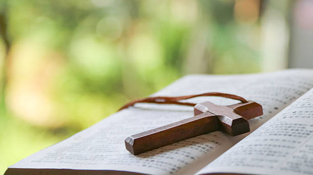 istock Wooden cross on old book with blurred background 2229071016
