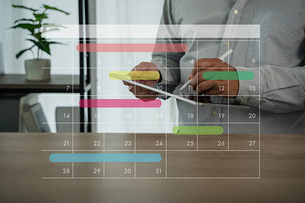 istock Business person using digital planner on smartphone and computer with monthly calendar overlay, planning schedule, organizing tasks, and managing time for productivity in modern office. 2229073568