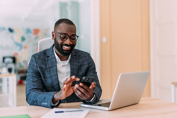 istock Businessman using laptop and texting on cellphone in the office. 2229073729