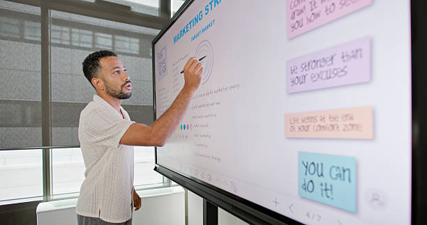 istock Mid Adult Multiracial Businessman Presenting on Interactive Whiteboard in Modern Office Setting 2229073916