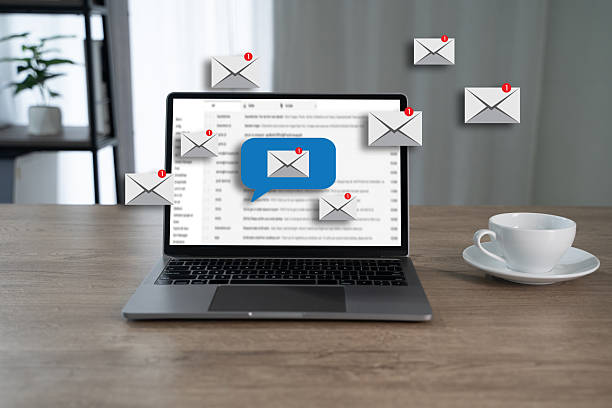 istock Email communication concept shown through notification icons flying around a laptop screen, representing a person managing new messages and inbox alerts in a digital workspace. 2229074180