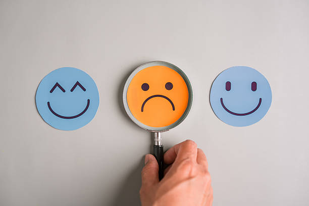 istock Magnifying glass on sad face and smiling emoticons, mood detection, emotional analysis, and mental health awareness in daily life. 2229074378