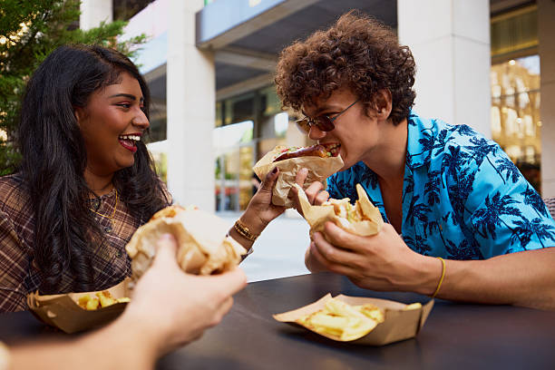 istock Multiracial couple sharing food and laughing during lunch 2229075604