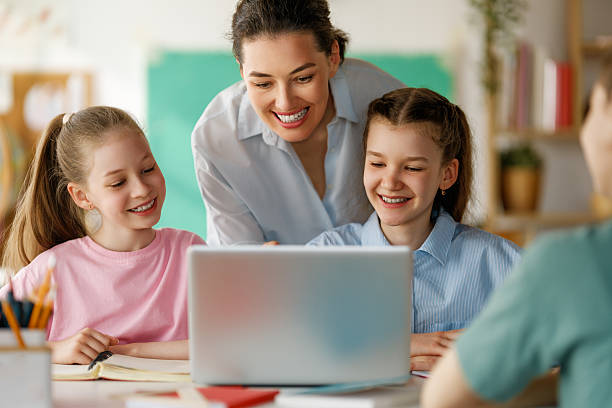 istock Happy kids and teacher at school 2229077223