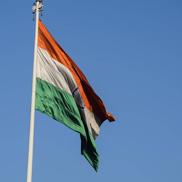 istock India flag flying high at Connaught Place with pride with plain white background, India flag fluttering, Indian Flag on Independence Day and Republic Day of India, tilt up shot, Har Ghar Tiranga 2229079539