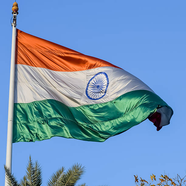 istock India flag flying high at Connaught Place with pride with plain white background, India flag fluttering, Indian Flag on Independence Day and Republic Day of India, tilt up shot, Har Ghar Tiranga 2229079577