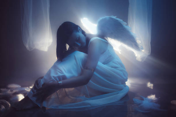 Angel on white cloud against blue clear sky with copy space