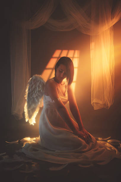 istock Angel Sitting On The Floor Against Yellow Light 2229083228
