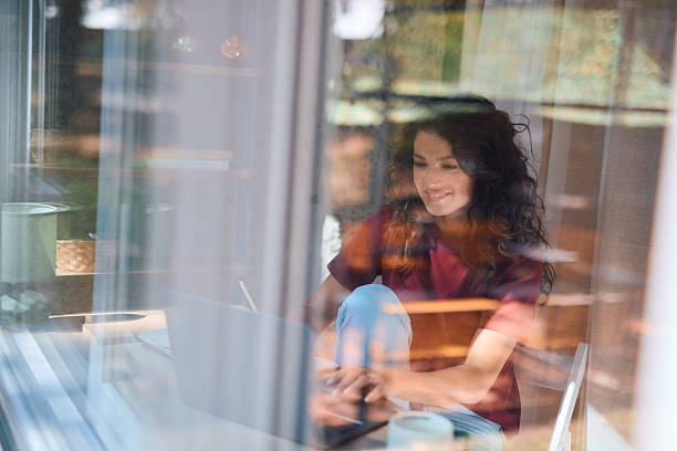 istock Young woman working from home using laptop near window 2229088494