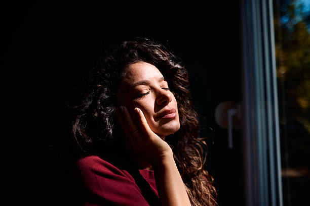 istock Serene young woman enjoying sunlight with closed eyes 2229088624