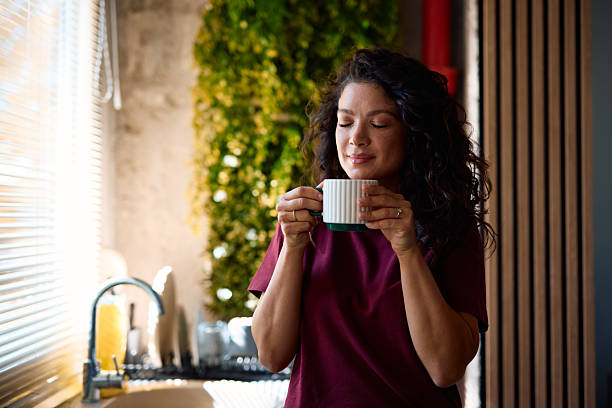 istock Woman enjoying a hot beverage in her modern kitchen 2229088695