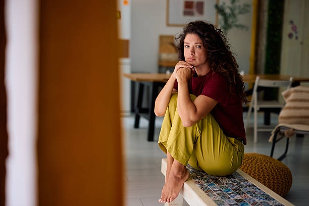 istock Lonely woman sitting on a bench at home feeling sad 2229088853