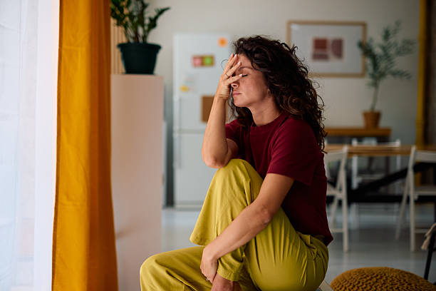 istock Sad woman sitting alone at home with hand on face 2229088881