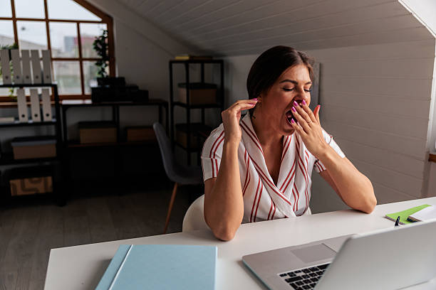 istock Tired Employee Yawning at Her Laptop 2229089351